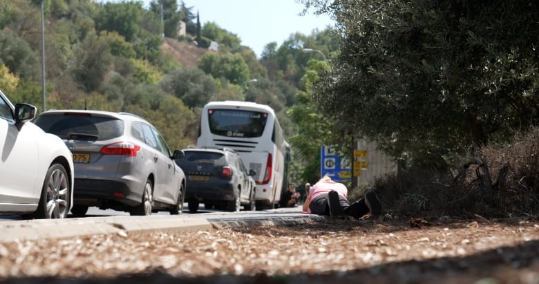 Motorists just outside the town of Safed dive for cover along the side of the road during a recent missile alert.   The community is just a few kilometers from Hezbollah launching sites in Lebanon,  providing only seconds of warning from sirens.