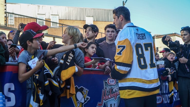 People waving things at one hockey player.