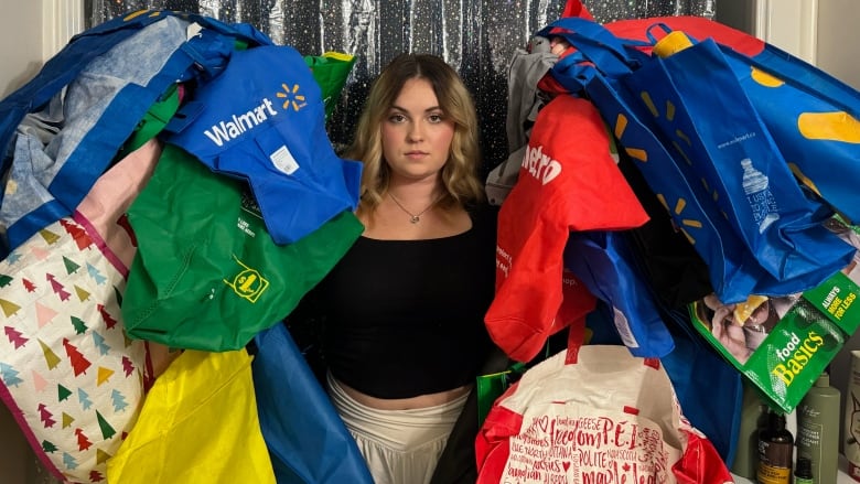 Megan Bishop surrounded by dozens of reusable bags. 