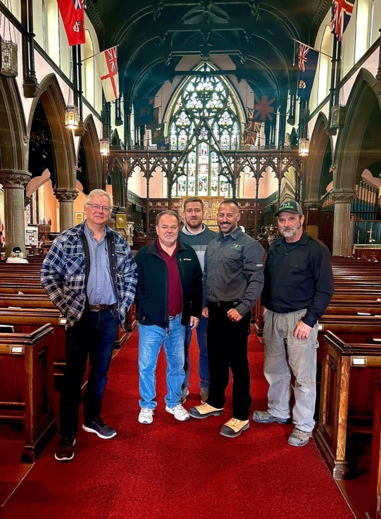 Five men stand in the middle of a church 