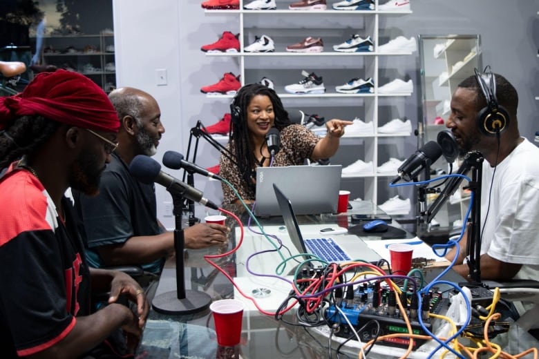 A group of people sit around microphones.