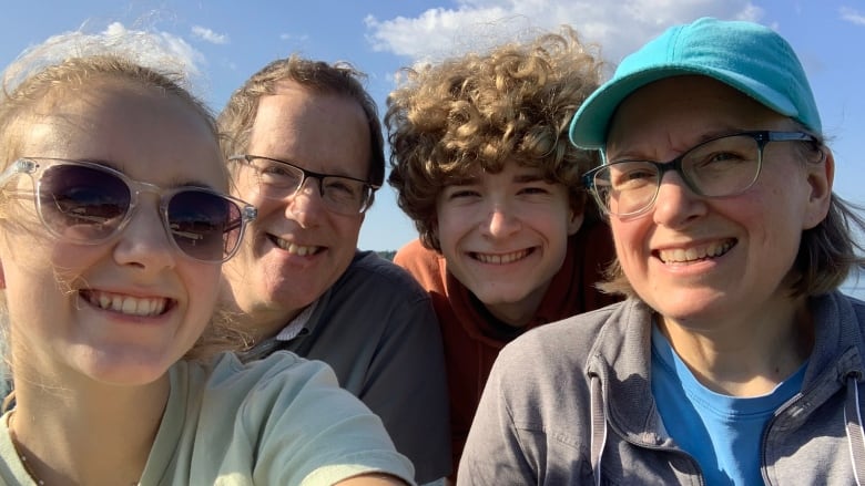 A selfie of a smiling four-person family