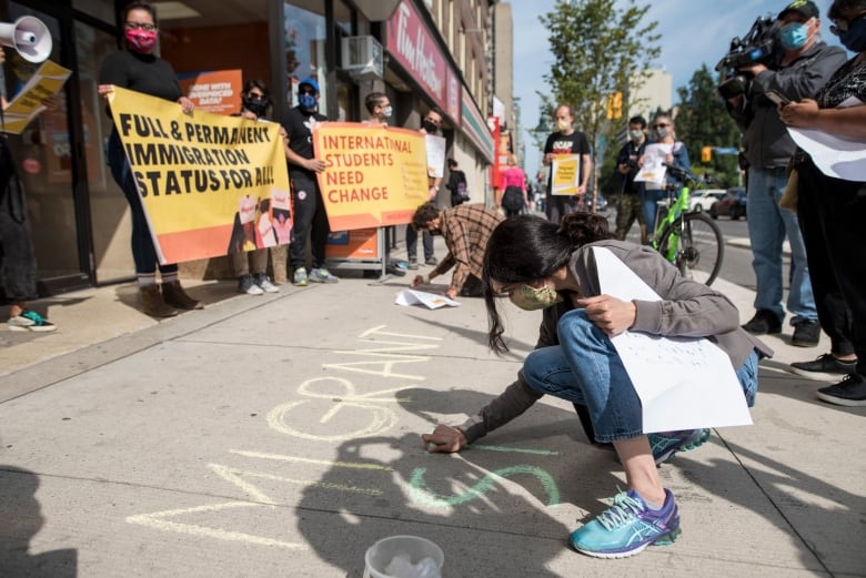 People gather outside Deputy Prime Minister Chrystia Freeland's office in Toronto for a rally led by current and former international students calling for changes to immigration rules during COVID-19, on Saturday, September 12, 2020.