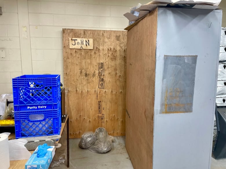 A plyboard box covers a portrait of John A Macdonald in a storage room.