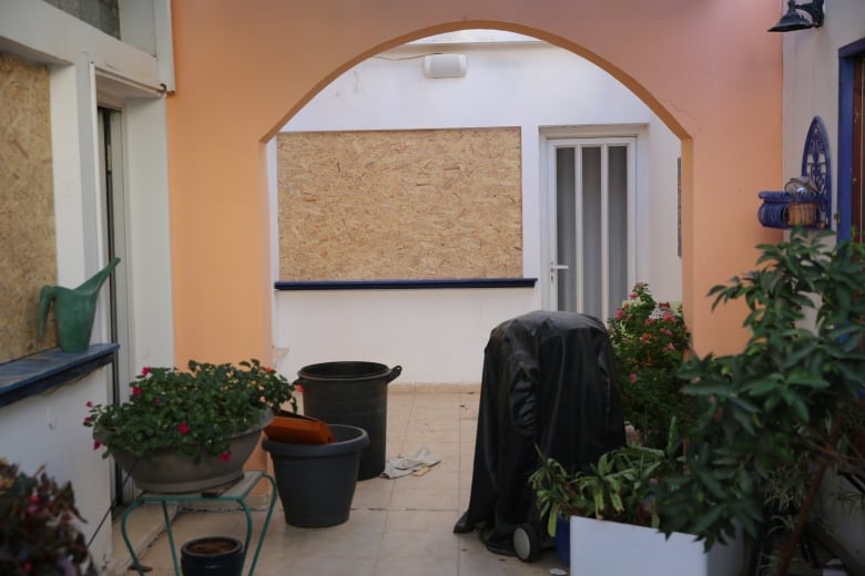 A piece of plywood covers a window on a home where glass should be.