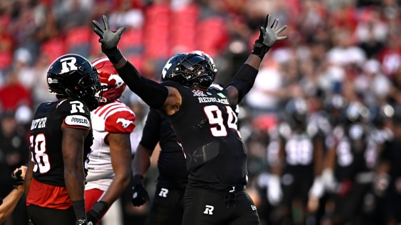 A football player celebrates after tackling the opposing quarterback.