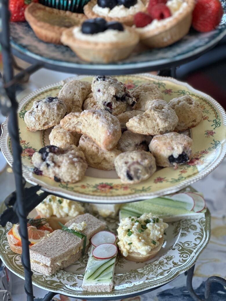 A tiered tray of tea sandwiches and pastries. 