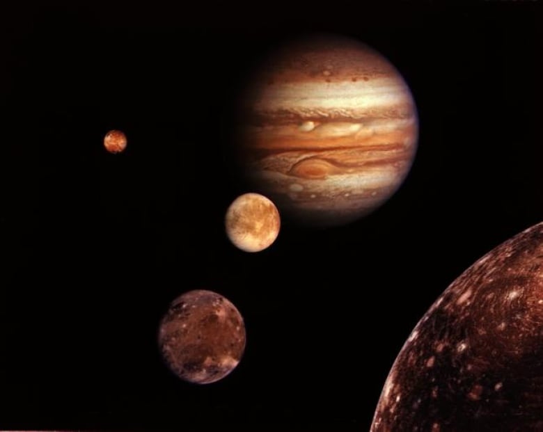 A sepia-toned image of Jupiter and three moons, with a fourth moon peeking into the frame on the lower right.