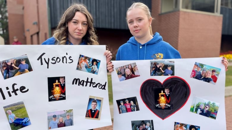 Two young women in blue hoodies hold posters showing a variety of photos of a smiling boy, with the text on one reading 