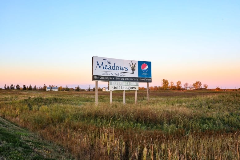 A sign in a field reads 