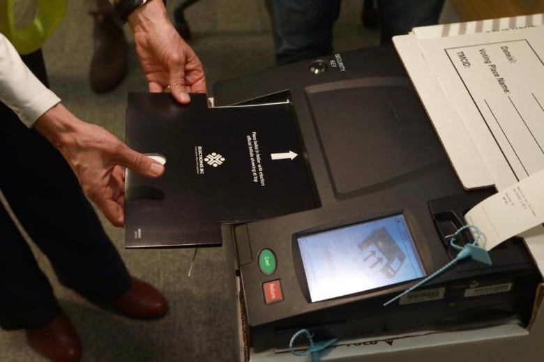 A person puts a card into an electronic machine