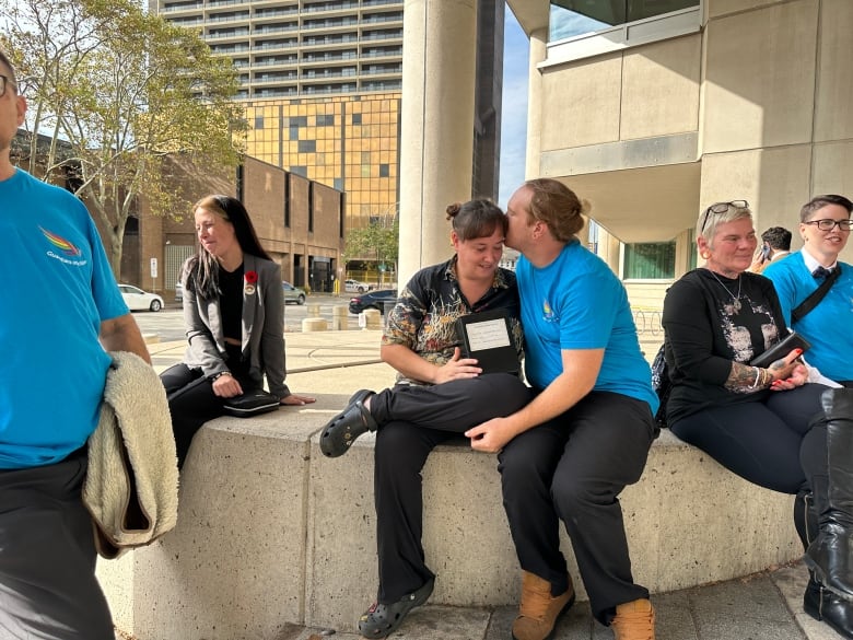 A woman and her husband outside a courthouse.