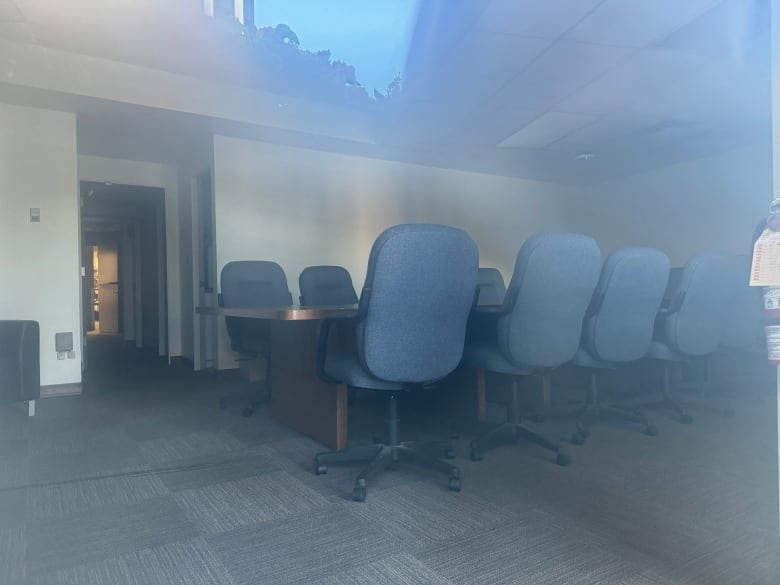 An empty boardroom with blue chairs.