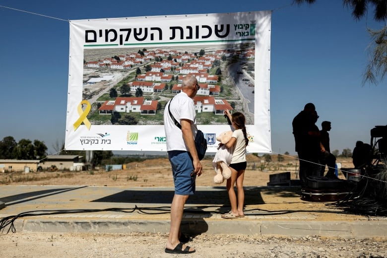 Members of Kibbutz Beeri look at an illustration of a new neighbourhood during its corner-stone event, after the deadly October 7 attack by Hamas gunmen from the Gaza Strip made major damage in Kibbutz Beeri, southern Israel, June 24, 2024 