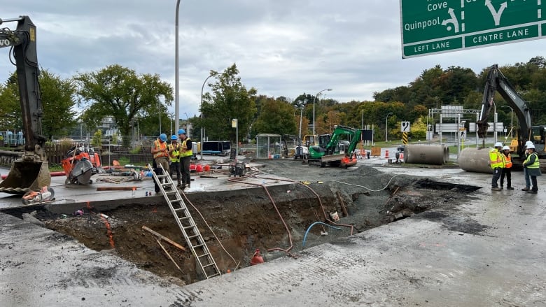 Construction crews are shown working at a site to fix a broken wastewater pipe.