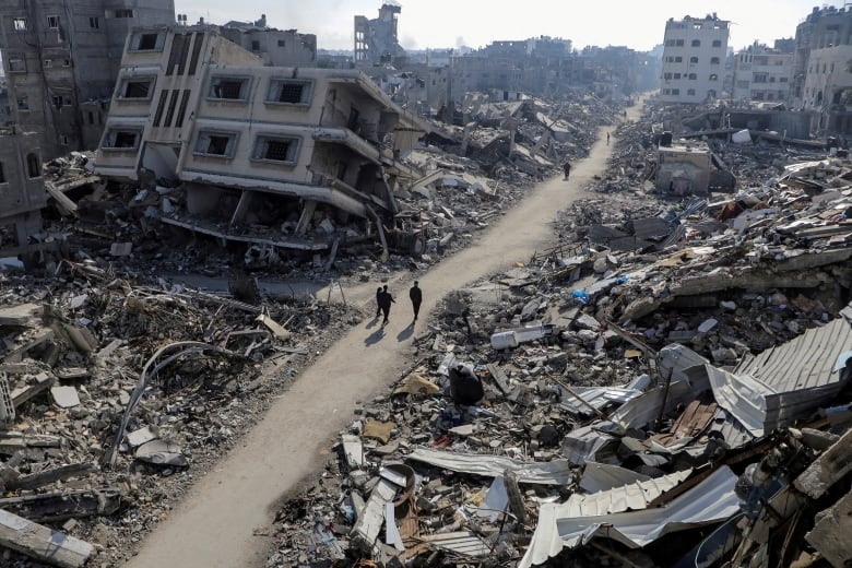 Palestinians walk past destroyed houses, amid the ongoing conflict between Israel and Hamas, in Jabalia refugee camp, in the northern Gaza Strip February 22, 2024.