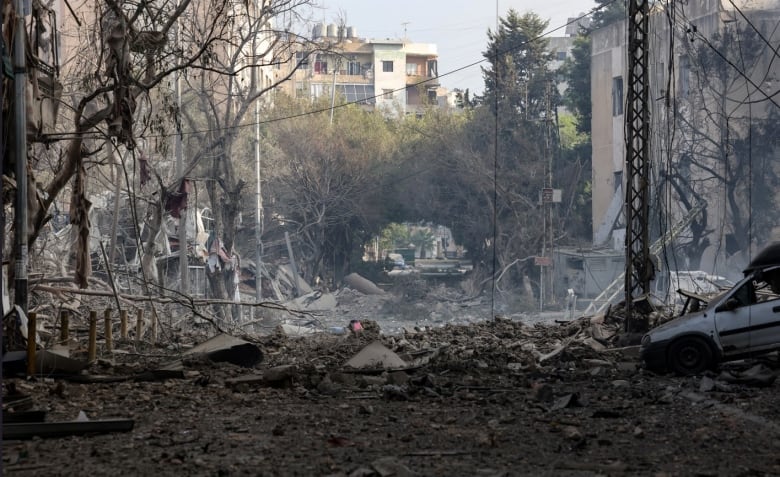 Rubble, destroyed vehicles and damaged building are seen on a street after an airstrike.