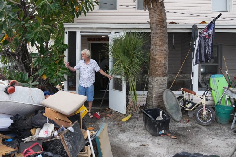 A man stands amid  debris