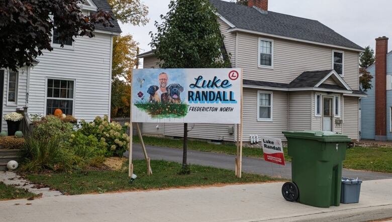 A hand-painted campaign sign with a portrait of a man surrounded by dogs on it.