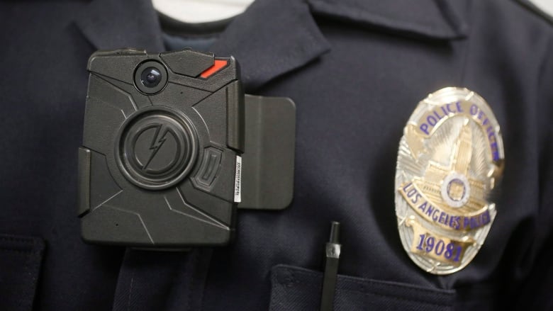 A close-up of a police officers chest with a camera there.