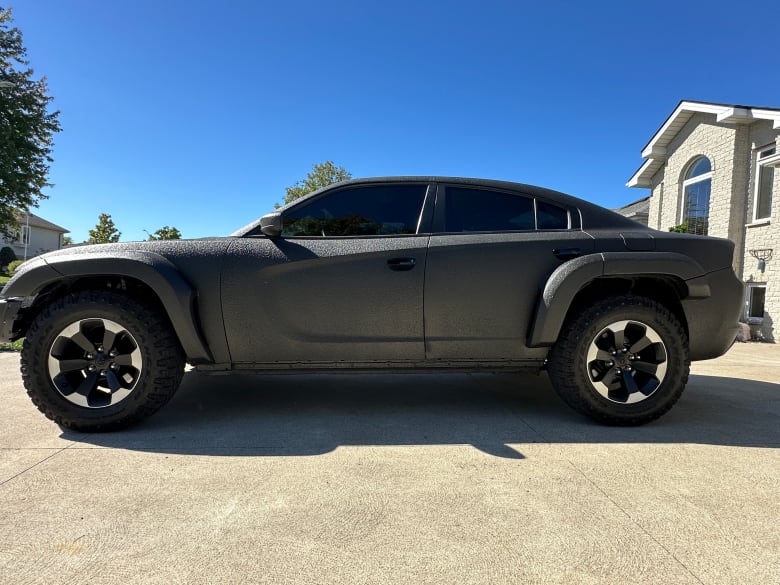 A side view of a black muscle car.