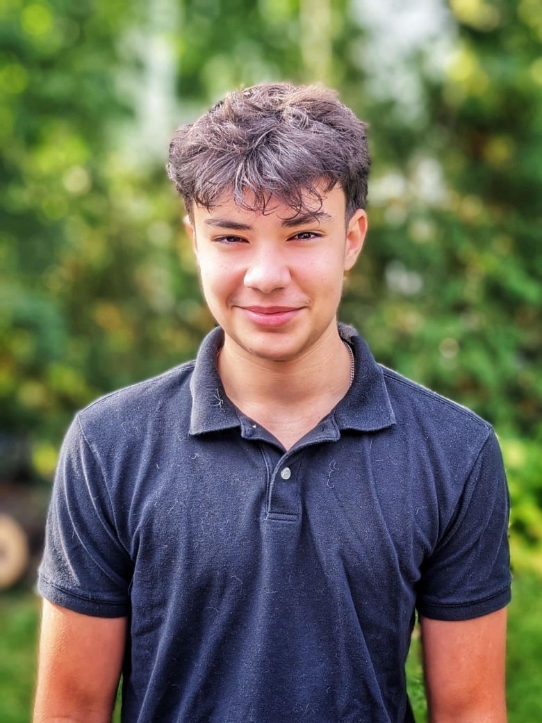 Teen boy wearing a blue golf shirt.