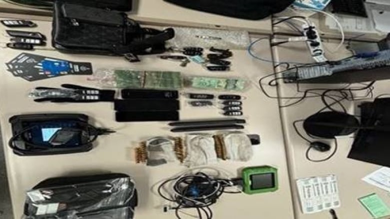 Multiple key fobs and car key programmers seized laid out on a table