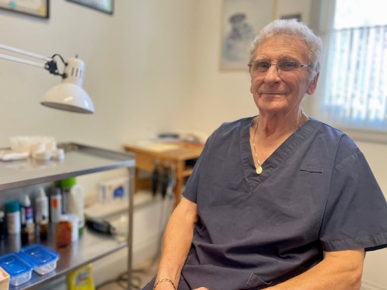 Keith Bettles sits in his clinic and smiles at the camera. 