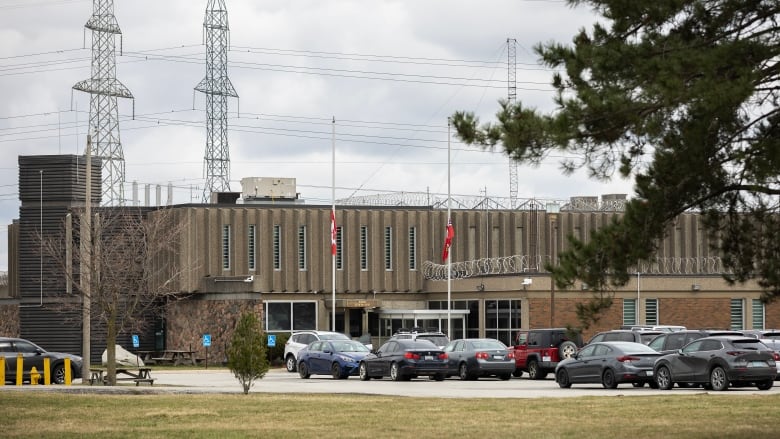 A prison seen from behind its parking lot on an overcast day.