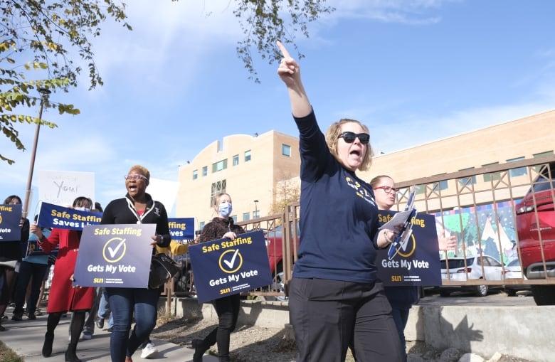 Healthcare workers from St. Pauls are rallying outside the hospital with signs