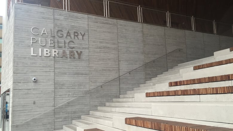 Steps leading into the main branch of the Calgary Public Library. Sign for library on wall behind.