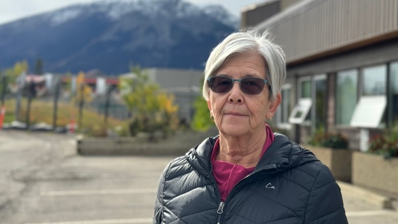 A woman stands outside a building.