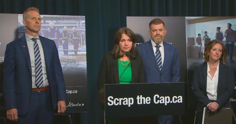 Four people stand at a podium.