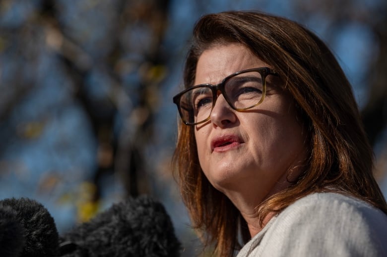 A close-up of a woman in glasses.