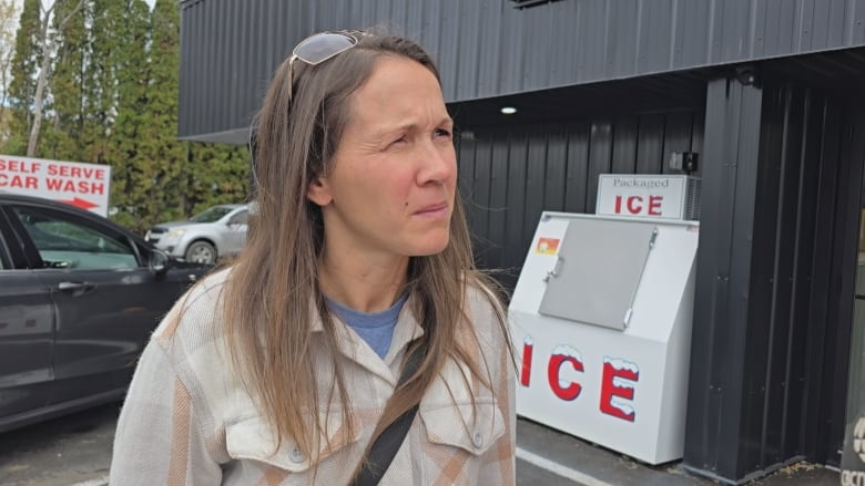 A woman standing outside in front of an ice box