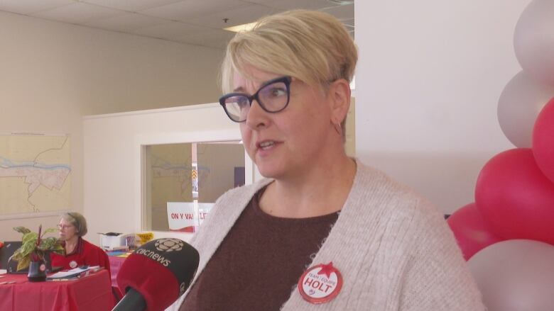 A woman with short blond hair and black glasses