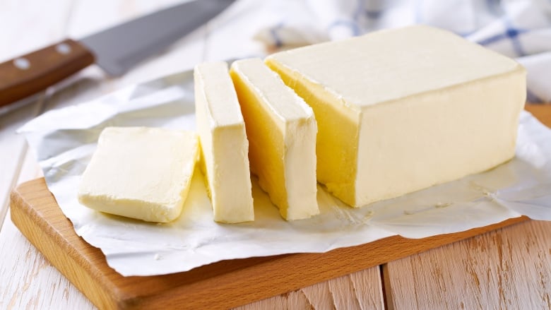 Sliced pieces of butter on a cutting board.