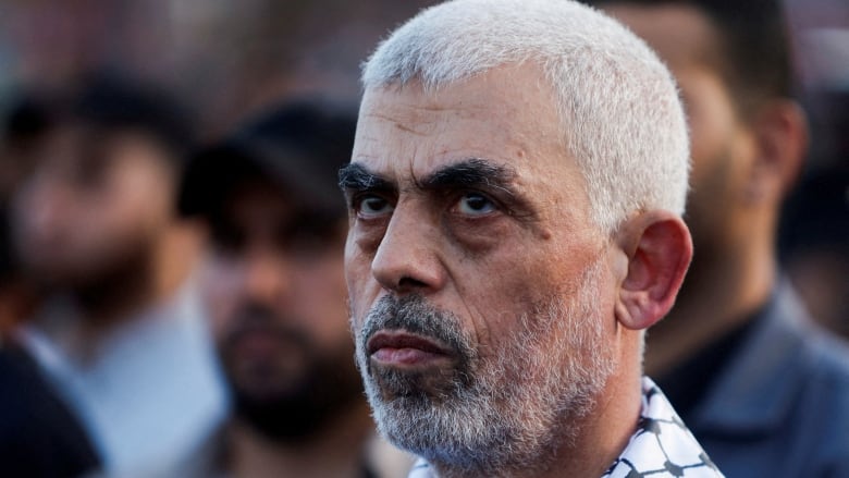 Hamas leader Yahya Sinwar looks on.