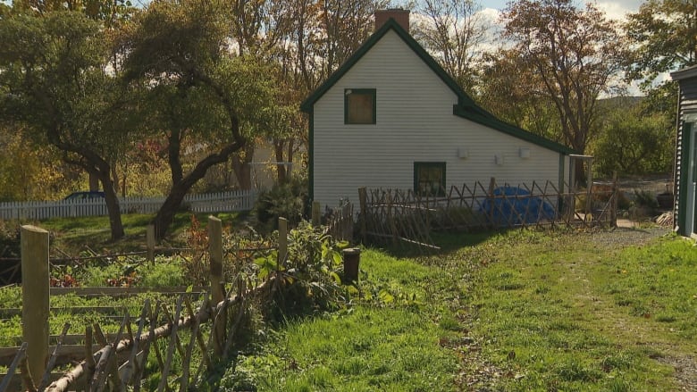 A farmhouse at the end of a grassy path.