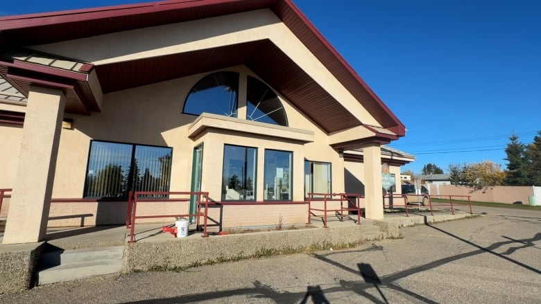 The Fairview Health Complex is a light brown building with red trim and large glass windows. 