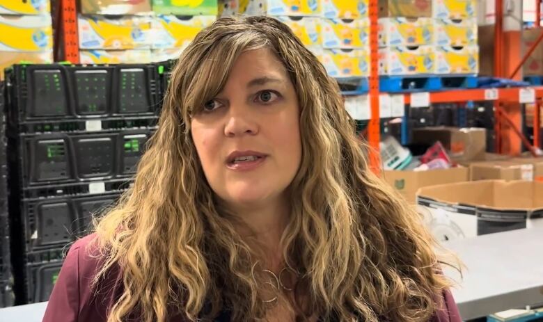 Woman speaking to reporter inside a food bank warehouse