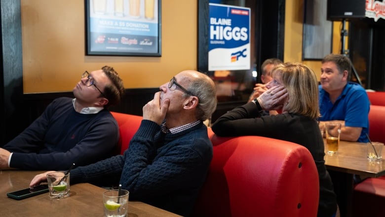 People sitting in booths, staring up