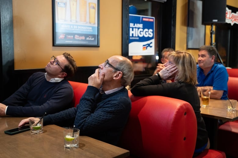 People sitting in booths, staring up