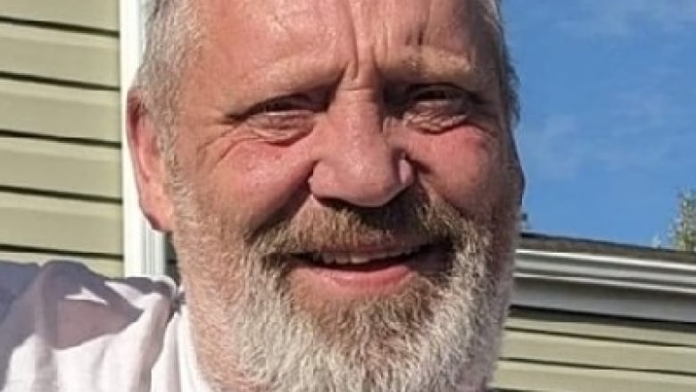 A man with glasses, a grey beard and brown hair