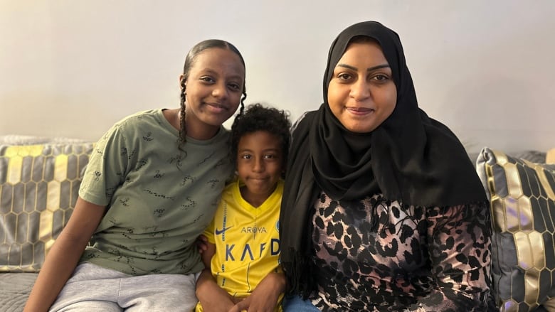 Bahga Elyamani sits with her kids Basma and Fawzi. Elyamani applied to bring her family from Sudan to Canada in April and still hasn't heard back from the federal government. Her elderly father died in August while waiting for approval. 