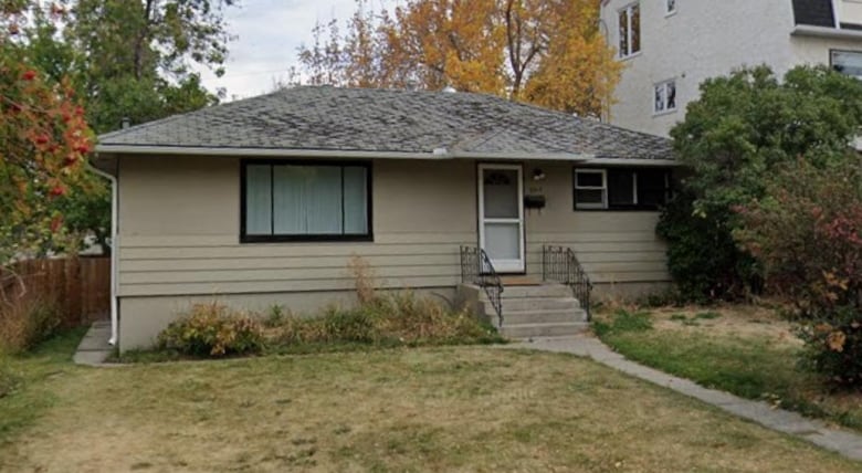 A bungalow with trees and grass around it.