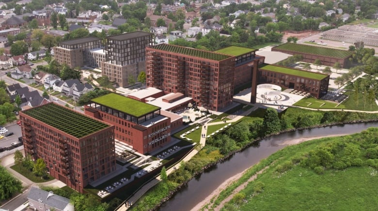 A computer image from overhead shows brick apartment buildings with green roofs on the left bank of a river 