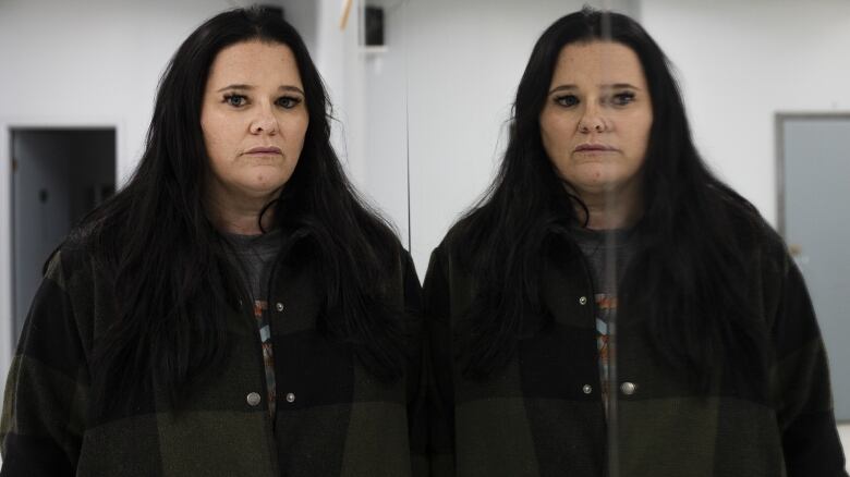 A woman stands in a dance studio.