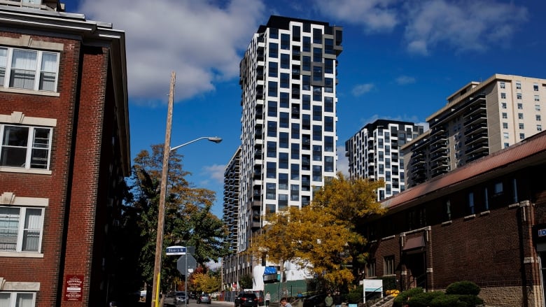 A residential street with a white condo standing prominently.