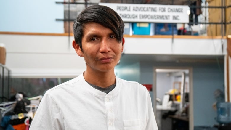 A headshot of a person with short dark hair, wearing a white shirt.